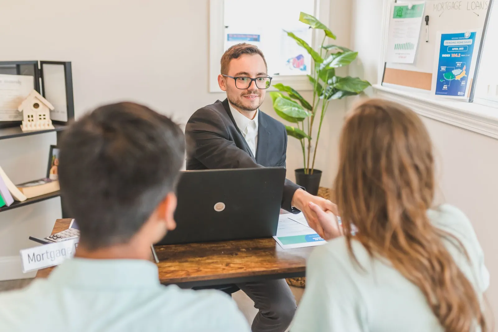 Mortgage adviser explaining financial calculations to clients in office