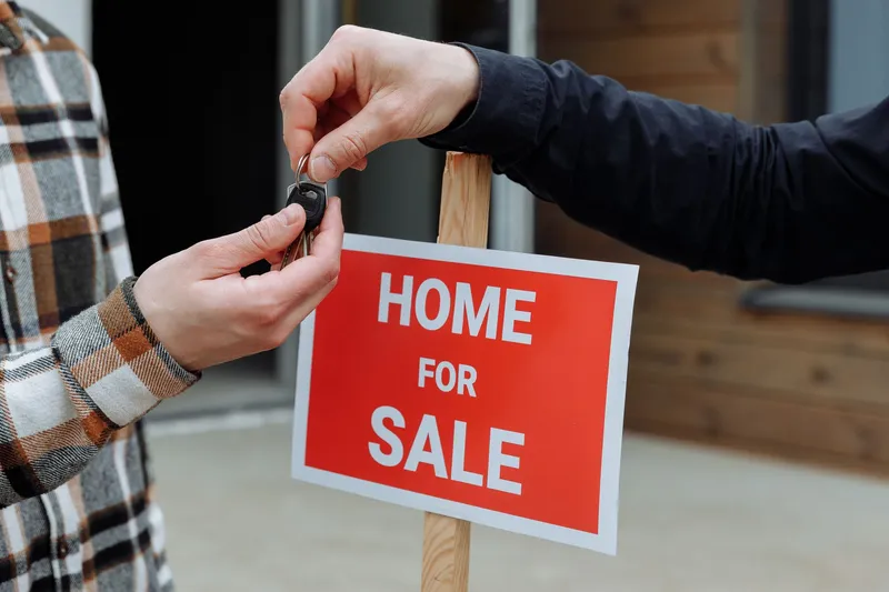 Hands holding the keys to a new house representing home settlement in NZ