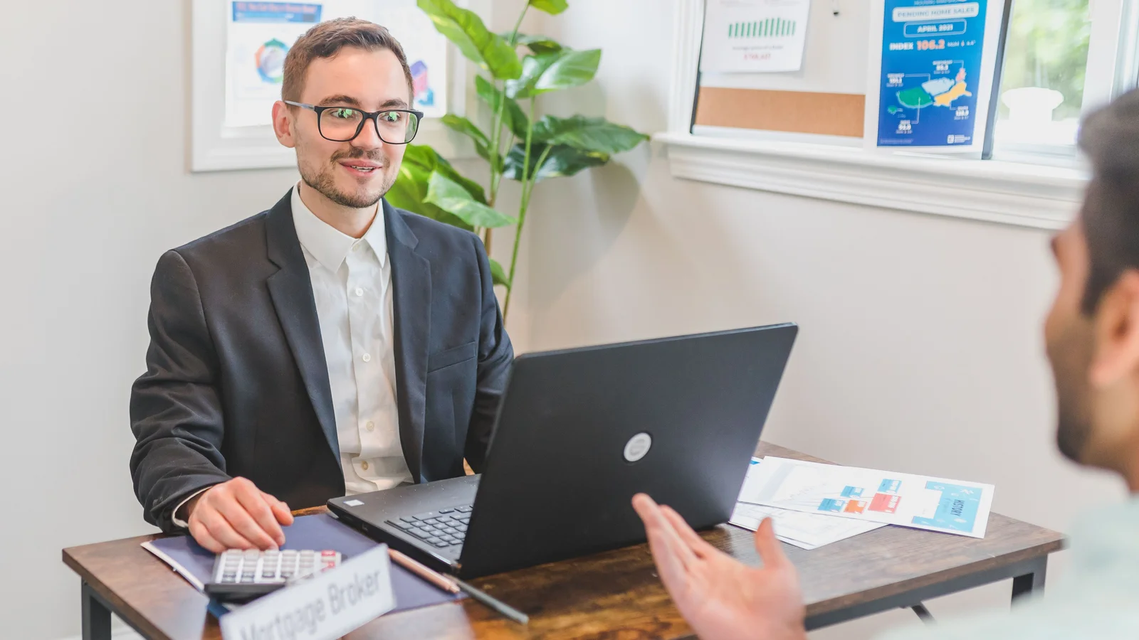 Home loan adviser and client discussing loan options in a modern office setting