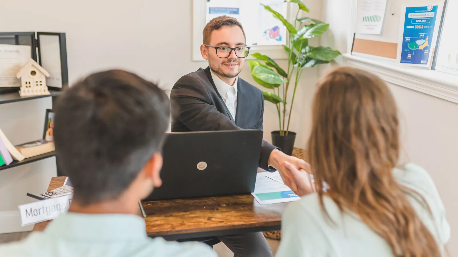 Home loan adviser reviewing mortgage structuring agreements with clients in an office