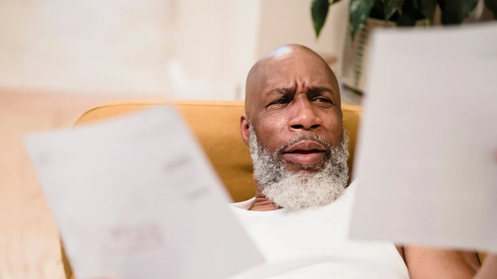 Older parent reading through home loan guarantee paperwork at a kitchen table