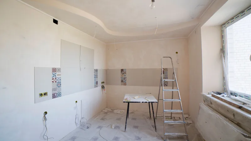 Modern kitchen interior during renovation, showing cabinetry and construction progress