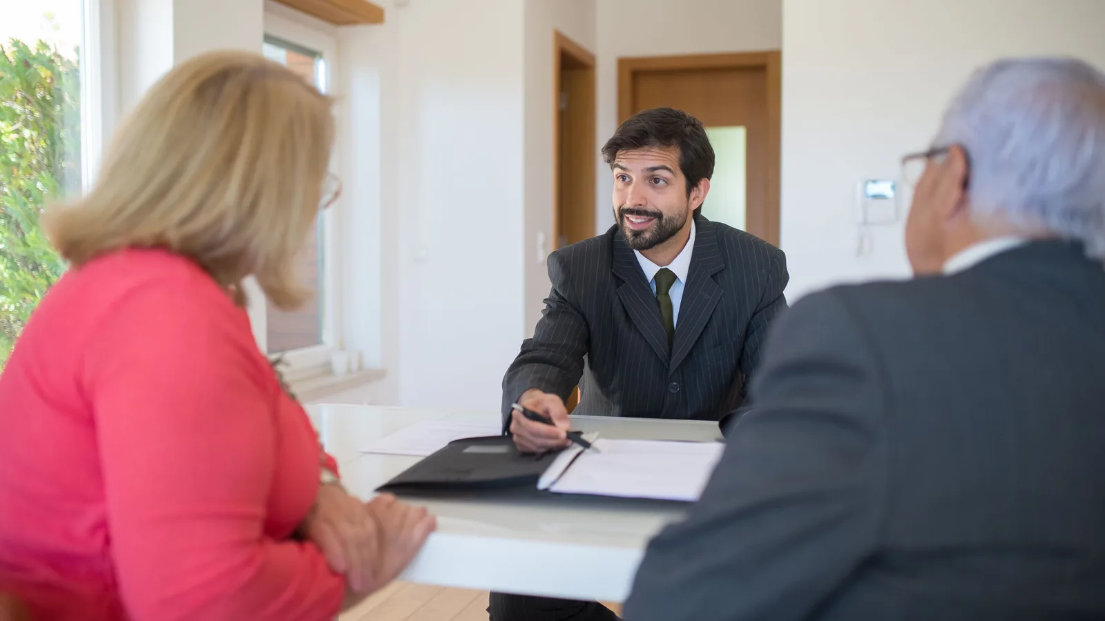 Home loan adviser talking through options with a couple across a table