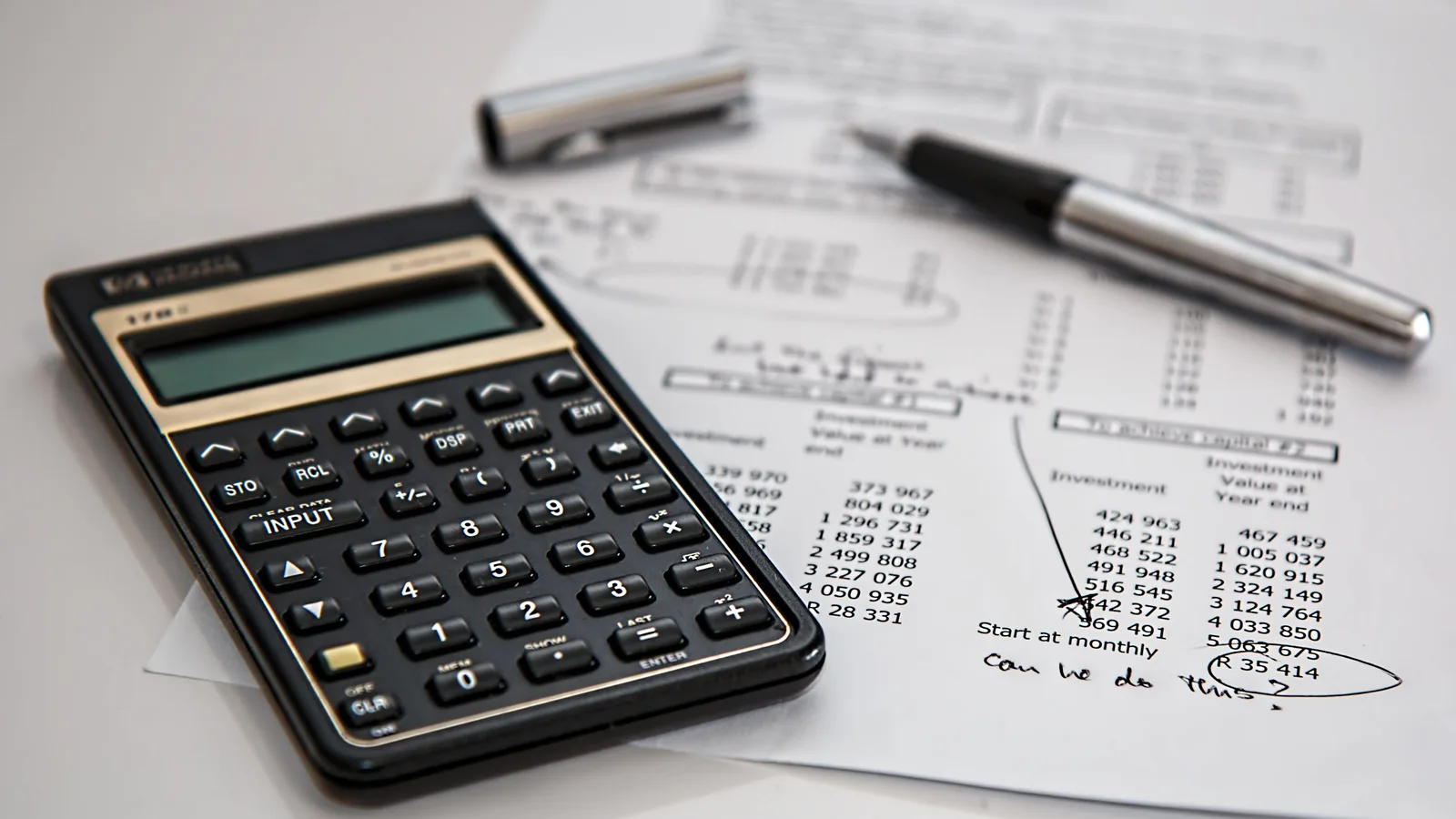 Calculator sitting on a printed spreadsheet of loan figures and repayment calculations