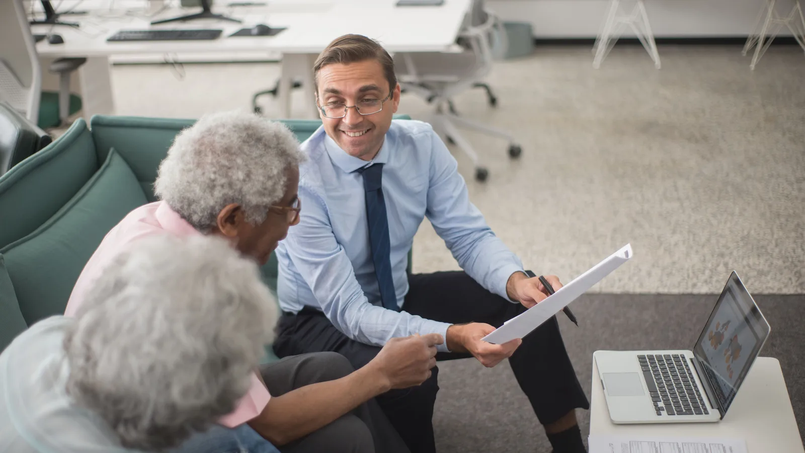Home loan adviser explaining paperwork to a couple across a desk