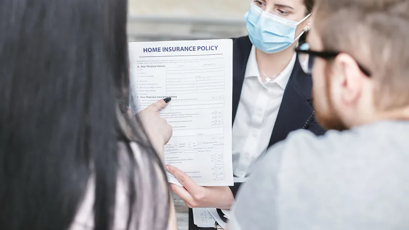 Couple reviewing home loan paperwork with an adviser at a table
