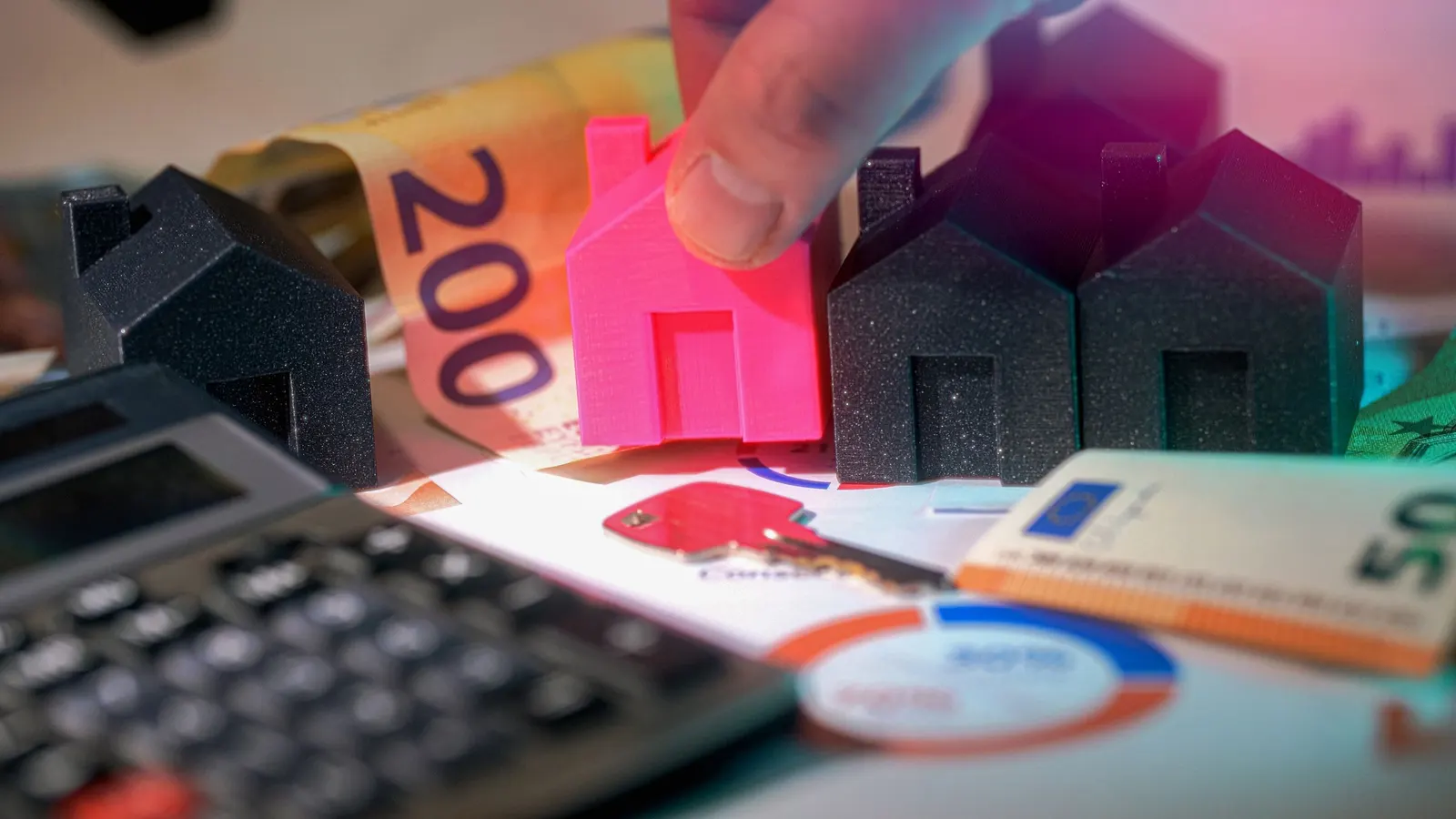 Model houses, cash, and a calculator laid out together, representing the numbers behind a home loan borrowing limit