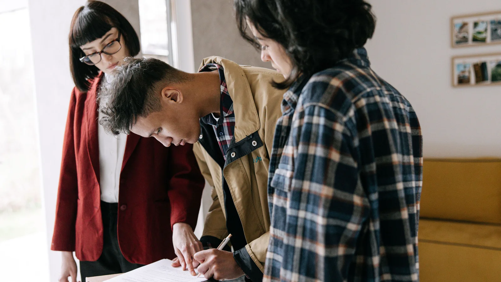 First home buyers signing property purchase documents with real estate paperwork