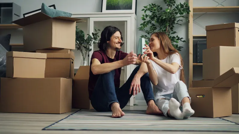 Smiling couple surrounded by moving boxes in their new home