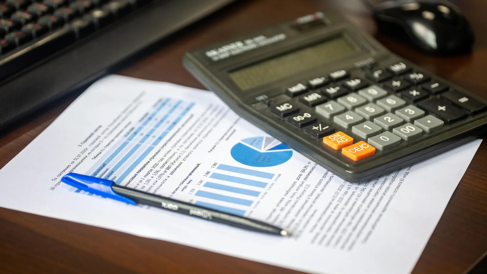 Financial paperwork, pen, and calculator on wooden desk illustrating mortgage structure comparison