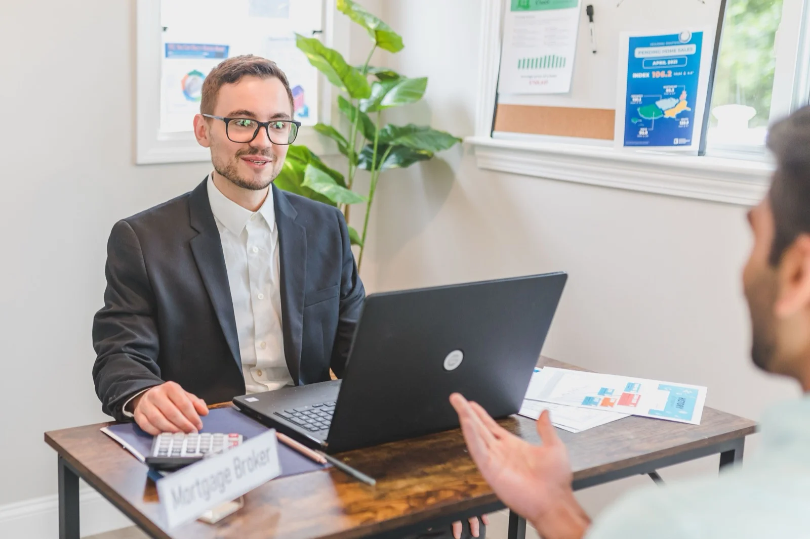 Mortgage adviser discussing self-employed loan options with clients in office