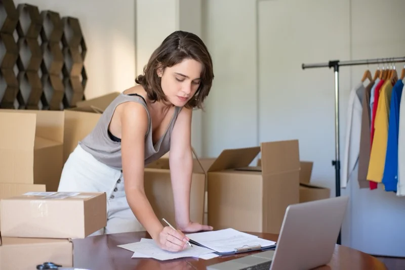 Self-employed small business owner reviewing financial figures on laptop