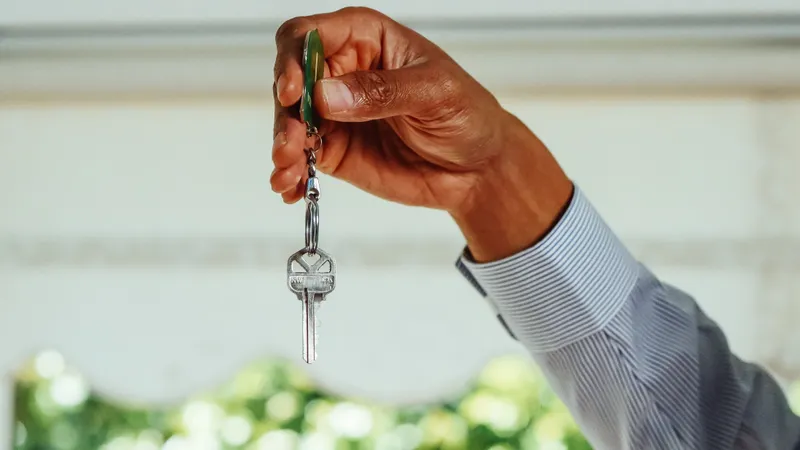 Hand holding house keys after settling on a first home